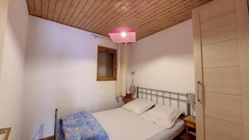 - une petite chambre avec un lit et une lumière rose dans l'établissement Schuss 6 appartement 4 pax au pied des pistes, à Saint-Jean-dʼAulps