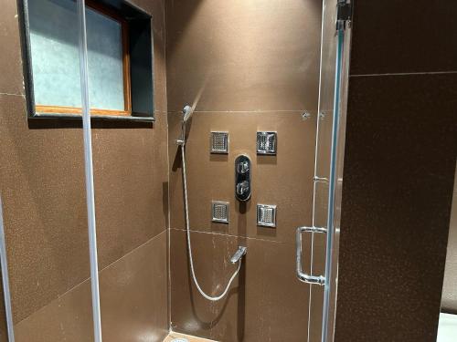 a shower in a bathroom with a glass door at Holiday Valley Hotels And Resorts in Denkanikottai