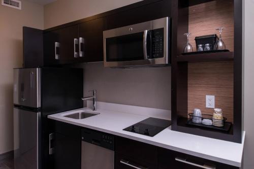 a kitchen with a sink and a microwave at TownePlace Suites by Marriott Saskatoon in Saskatoon