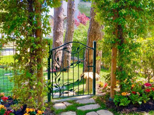 a gate in a garden with flowers and trees at Beach Garden Paradise in Durrës