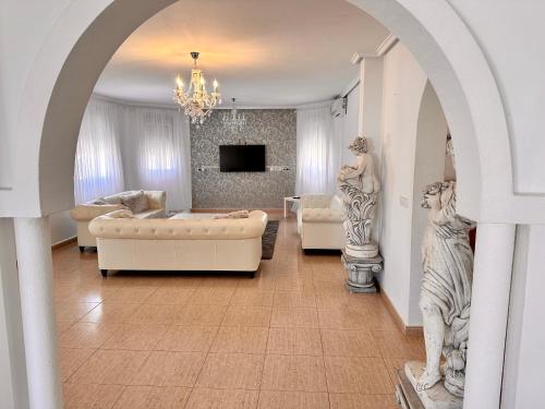 sala de estar con sofá y 2 estatuas en Villas Yanina Luxe Gran Alacant, en Puerto Marino