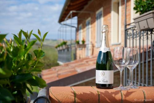 eine Flasche Wein und zwei Gläser auf dem Balkon in der Unterkunft Agriturismo Cascina Sciulun in Monforte dʼAlba