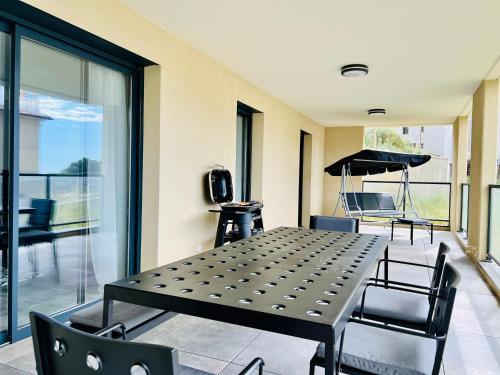 - une table et des chaises dans une chambre avec terrasse dans l'établissement BEL'ORIZONTE B , proche centre ville et plage, à Propriano