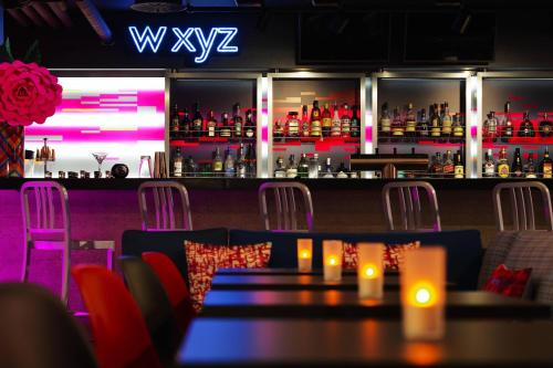 a bar with tables and chairs in a restaurant at Aloft Stuttgart in Stuttgart