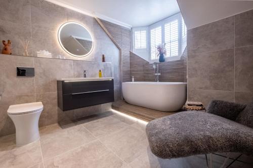 a bathroom with a tub and a sink and a toilet at The Arran, St Andrews in St. Andrews