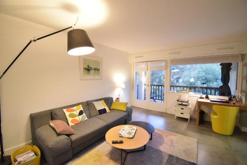 un salon avec un canapé et une table dans l'établissement Bourret - Bel appartement avec grande terrasse - rénové avec goût proche centre ville, lac et plages d'HOSSEGOR, à Soorts-Hossegor
