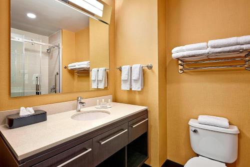 La salle de bains est pourvue d'un lavabo, de toilettes et d'un miroir. dans l'établissement TownePlace Suites by Marriott London, à London