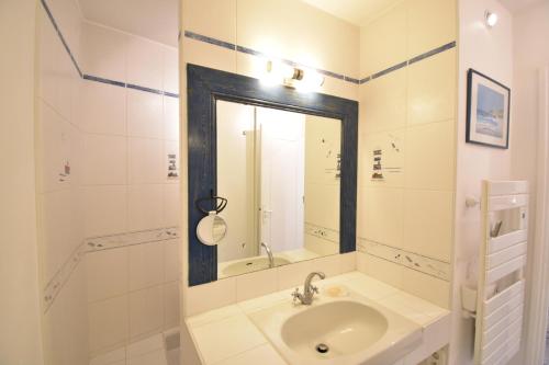 une salle de bain blanche avec un lavabo et un miroir dans l'établissement Bourret - Bel appartement avec grande terrasse - rénové avec goût proche centre ville, lac et plages d'HOSSEGOR, à Soorts-Hossegor