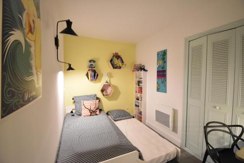 une petite chambre avec un lit dans une pièce dans l'établissement Bourret - Bel appartement avec grande terrasse - rénové avec goût proche centre ville, lac et plages d'HOSSEGOR, à Soorts-Hossegor