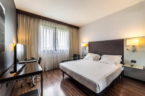 a hotel room with a bed and a desk at AC Hotel Padova by Marriott in Padova