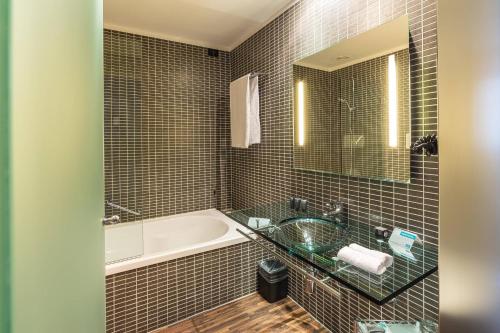 a bathroom with a tub and a sink at AC Hotel Padova by Marriott in Padova