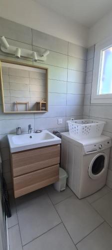 a bathroom with a sink and a washing machine at Maison avec piscine entre garrigue et Cévennes in Cazilhac