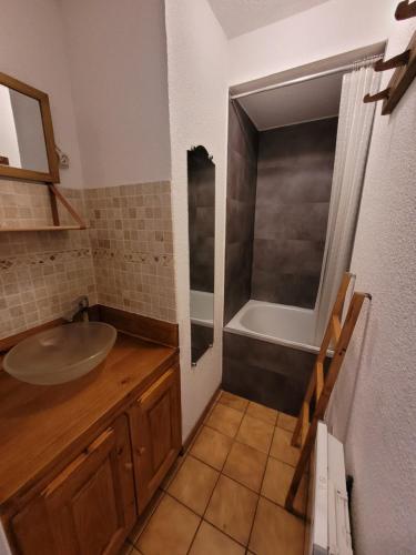 La salle de bains est pourvue d'un lavabo et d'une baignoire. dans l'établissement Le Flocon, Joli Rez de Jardin, 5 personnes, Barbecue & Transats, proche du centre des Rousses, Draps inclus et Boîte à clés, aux Rousses