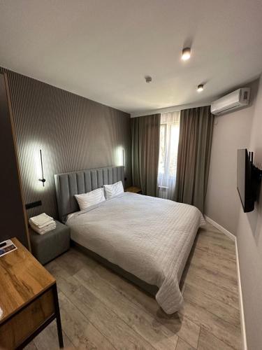 a bedroom with a large bed and a wooden floor at Dream Hotel in Almaty