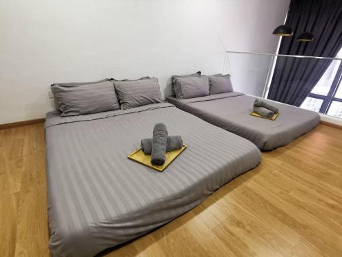 two beds with mitts on them in a room at EkoCheras Loft 5 pax, #Snooker #AboveMall #Balcony #FreeCarPark in Kuala Lumpur