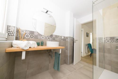 een badkamer met een wastafel en een spiegel bij Apartamentos turísticos Praia de Seselle, terraza y jardín a un paso de la playa in Ares