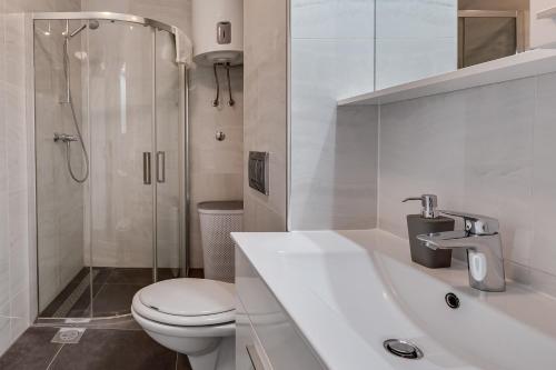 a white bathroom with a toilet and a shower at Villa Stjepanovic in Tribanj-Krušćica