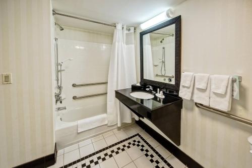 那不勒斯的住宿－溫徹斯特費爾菲爾德套房酒店，一间带水槽、浴缸和镜子的浴室