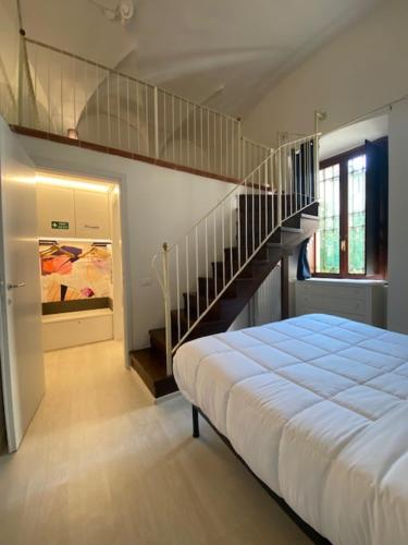 a bedroom with a bed and a stair case at DUOMO26 BOUTIQUE APARTMENT in Desenzano del Garda