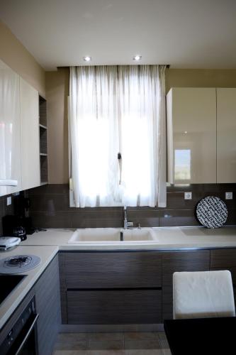 a kitchen with a large sink and a window at Elioj house in Leptokaria