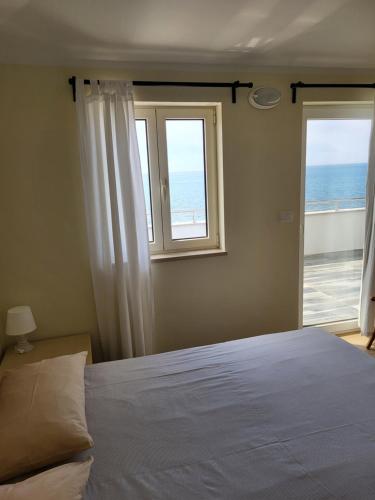 a bedroom with a bed and a window with the ocean at Apartments Alen in Umag