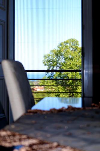 a chair sitting in front of a window with a tree at Elioj house in Leptokaria