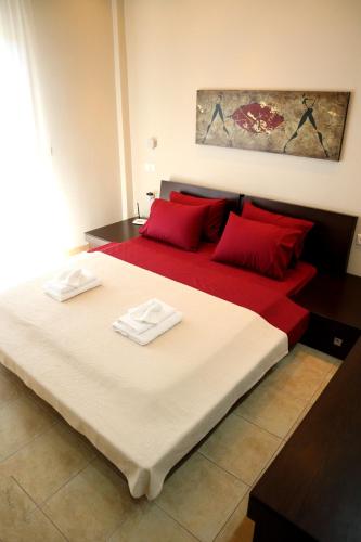 a bedroom with a large bed with red pillows at Elioj house in Leptokaria