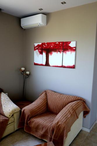 a living room with a couch and a painting on the wall at Elioj house in Leptokaria