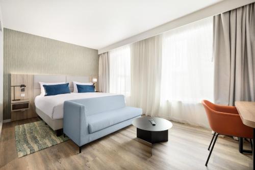 ロワシー・アン・フランスにあるResidence Inn by Marriott Paris Charles de Gaulle Central Airportのベッドとソファのあるホテルの部屋