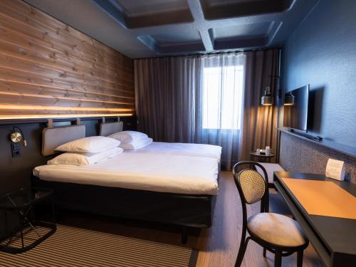 una camera d'albergo con un grande letto e una scrivania di Original Sokos Hotel Lappee a Lappeenranta