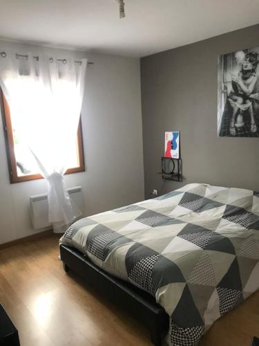 um quarto com uma cama com um edredão preto e branco em Vintage house em Giffaumont