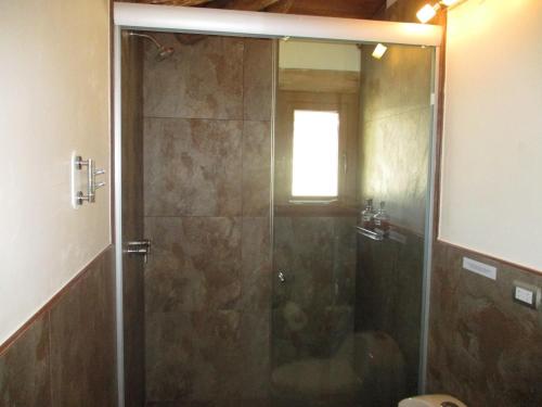 a shower with a glass door in a bathroom at Casa de Oren in Pisac