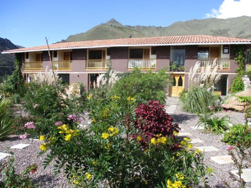 a garden in front of a house with flowers at Casa de Oren in Pisac