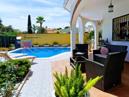 un patio avec des chaises et une piscine dans l'établissement Villa SIA, à Torrevieja