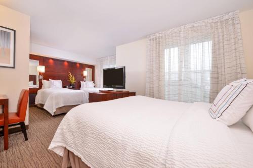 Residence Inn by Marriott North Conway في نورث كونويه: غرفة فندقية بسريرين وتلفزيون بشاشة مسطحة