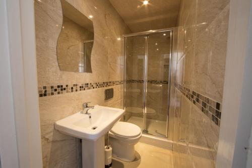 a bathroom with a toilet and a sink and a shower at Royal London Hotel By Saba in London