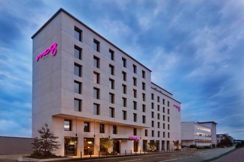 a white building with a pink sign on it at Moxy Rapperswil in Rapperswil-Jona