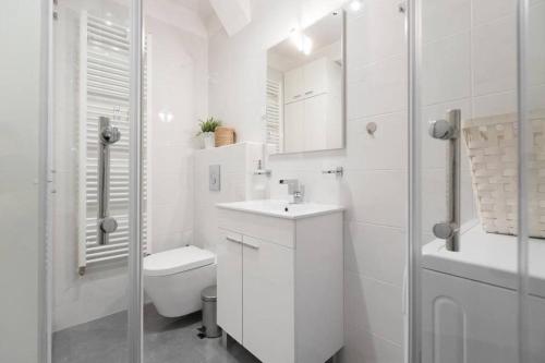 a white bathroom with a toilet and a sink at City center 2bedroom apartment in Zagreb