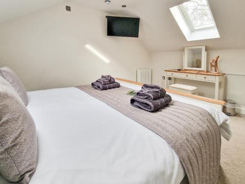 a bedroom with a white bed with towels on it at The Lodge in Skipwith