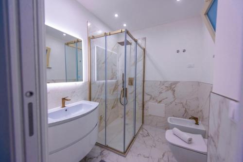 een badkamer met een douche, een wastafel en een toilet bij Kapitano Apartments in Taormina