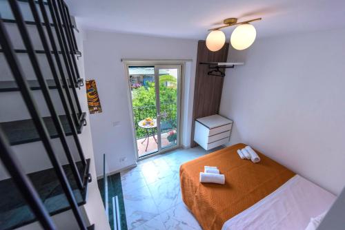 een kleine slaapkamer met een bed en een balkon bij Kapitano Apartments in Taormina