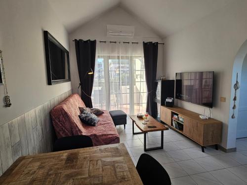 sala de estar con sofá y TV en Casa Azul Montecastillo L7 en Caleta de Fuste