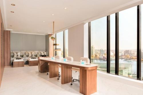 a living room with a table and large windows at the DOUGLAS, Autograph Collection in Vancouver