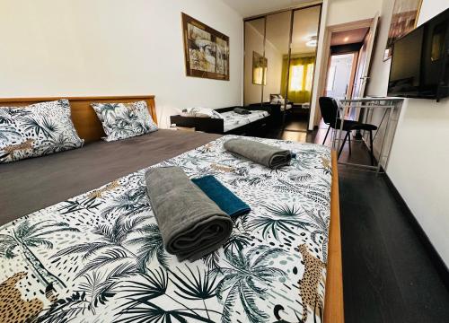 een slaapkamer met een groot bed met een deken erop bij The NICE rose - 3 rooms, 3 air cond, 3 TV, 3 fans, WIfi everywhere, Netflix, balcony for smokers, parking possible in Nice