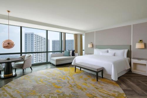 ein Schlafzimmer mit einem großen weißen Bett und einem großen Fenster in der Unterkunft The Westin Surabaya in Surabaya