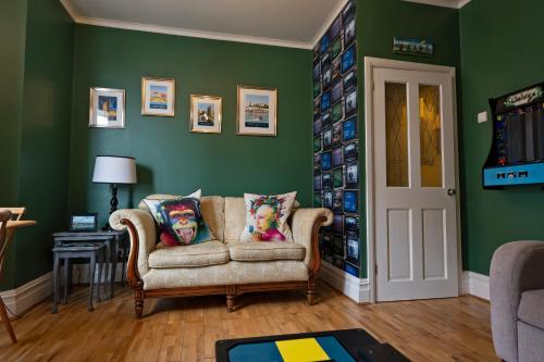 a living room with a couch and green walls at Albert's Rest in Ramsgate