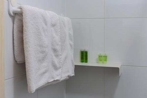 a white towel hanging on a towel rack in a bathroom at De Witte Meren in Keerbergen