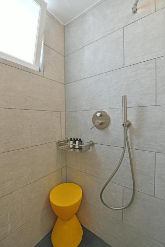 a bathroom with a yellow toilet and a shower at Hydra Icons in Hydra