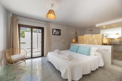 聖安東尼奧的住宿－Buenavista Cala Salada，卧室配有一张白色大床和一把椅子