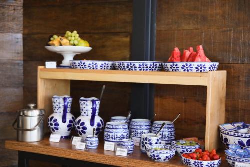 a shelf with blue and white vases and bowls of fruit at Hotel Black Inn Flamboyant in Goiânia